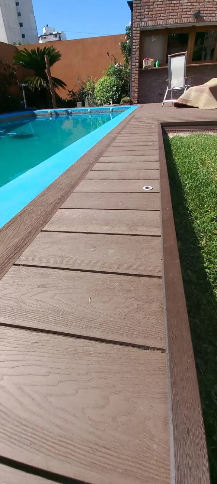 Deck de madera restaurado junto a una pileta